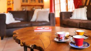 Ein gemütliches Wohnzimmer mit Couchtisch, zwei Sofas und einem Bücherregal im Hintergrund.