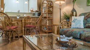 A cozy living area with wicker furniture, a glass coffee table, and a patterned sofa. - Beautiful 1BR/2BA ground floor unit, Kamaole Sands resort. 1 min walk to beach! (Kihei)