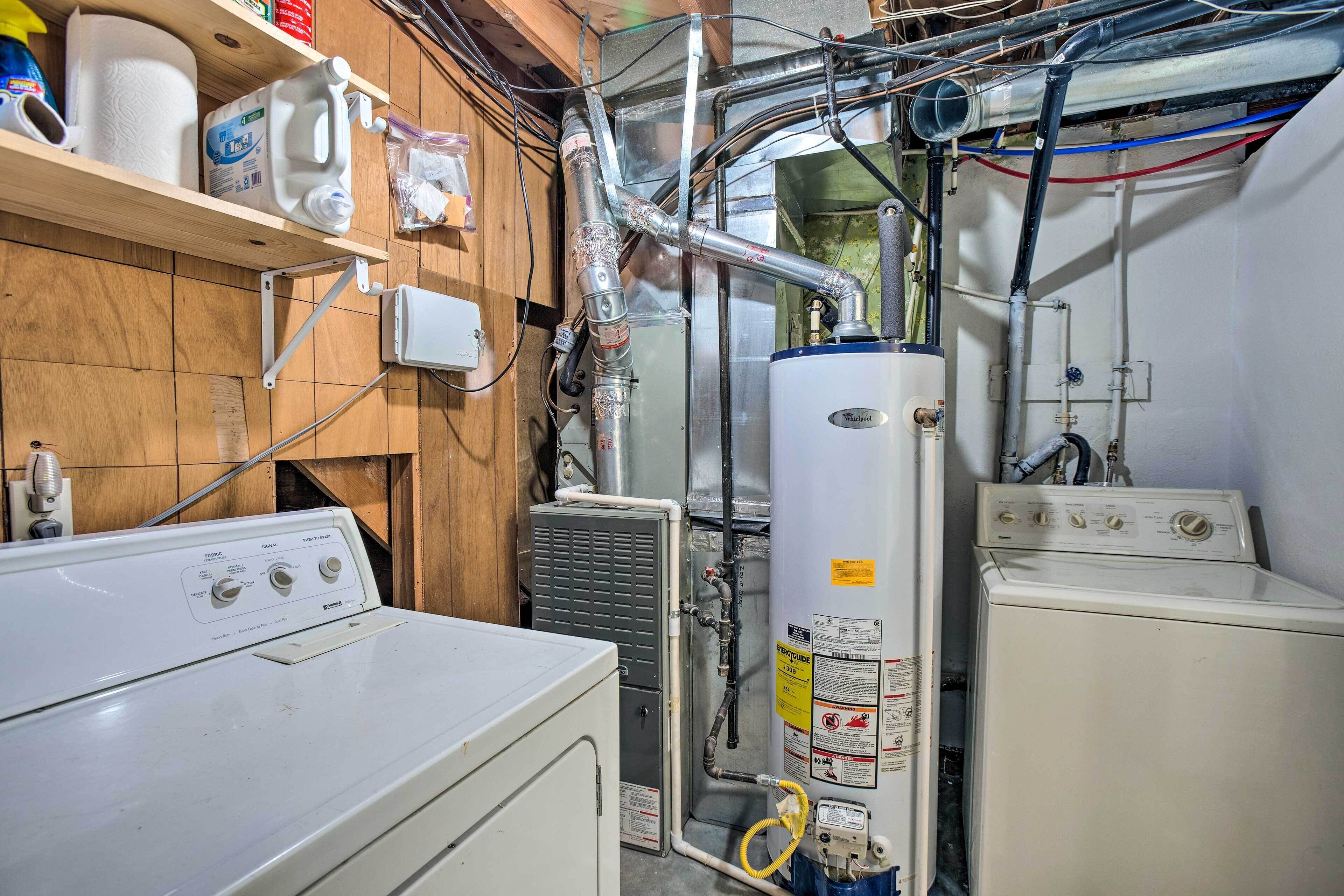 A laundry room with a washer, dryer, and a water heater.