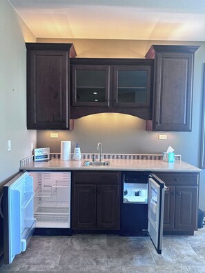 A kitchen with dark wooden cabinets, a built-in dishwasher, and a countertop with a sink. - 17th Fairway Retreat | Lake Views, Golf, 4BD 4.5BA (Brule)