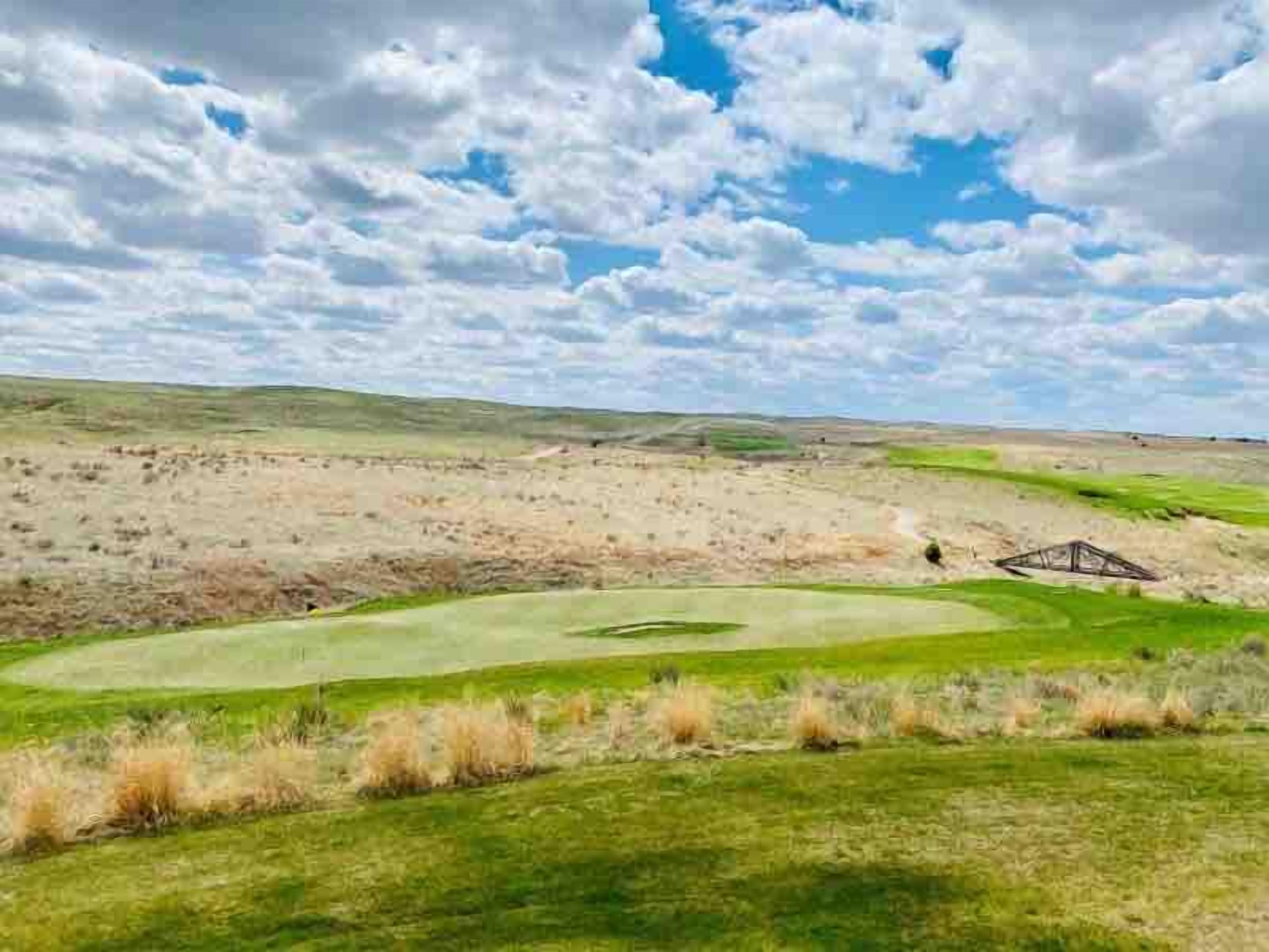 Un campo da golf con cielo sereno e qualche nuvola.