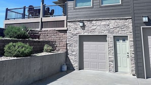 A two-story house with a stone facade, a covered porch, and a garage.