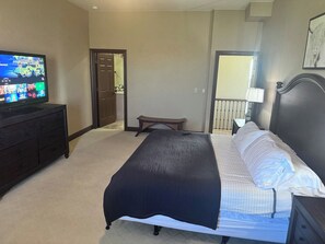 A bedroom with a bed, a dresser, a television, and a door leading to another room. - 17th Fairway Retreat | Lake Views, Golf, 4BD 4.5BA (Brule)