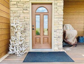 Enter through the stone-framed entrance, featuring a brown door and decorative antler arrangement.