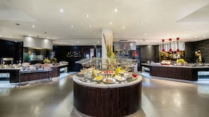 A modern hotel lobby with a central buffet area featuring a variety of food items and a decorative centerpiece. - Glenmarie Hotel & Golf Resort (Shah Alam)