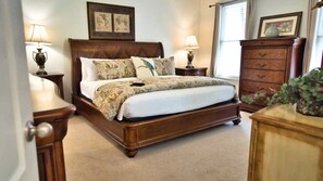A bedroom with a wooden bed, two bedside tables with lamps, a dresser, and framed pictures on the wall. - Spacious Family Home, Private Pool, 6-Seater Golf Cart! ~ Heartbeat of Seagrove (Santa Rosa Beach)