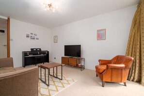 Basic Apartment, Multiple Beds | Living room | TV, books