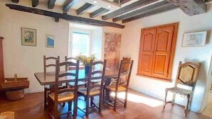 Un espace repas avec des meubles en bois, une grande fenêtre et une vue sur l’extérieur.