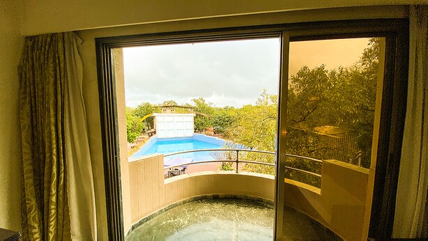 Una habitación con un amplio ventanal corredera que da a una zona de piscina.