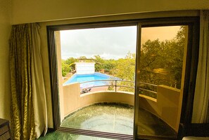 A room with a large sliding glass door leading to a pool area.