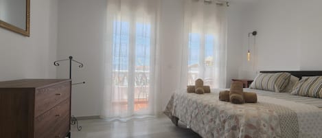 Quarto com cama, cómoda de madeira, espelho e ar condicionado.