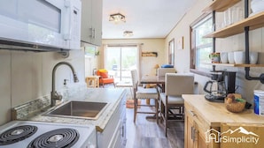 A compact kitchen with a stove, sink, and dining area. - Mountain Cabin by Twin Lakes w/ BBQ and Fast WiFi (Twin Lakes)
