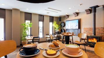 A cozy restaurant with wooden tables, chairs, and a fireplace.