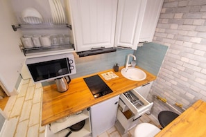 Apartamento | Cozinha privada | Geladeira, micro-ondas, cooktop, cadeirão de bebê