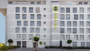A modern hotel building with multiple floors, large windows, and a prominent B&B Hotels sign.