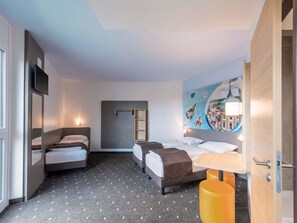 A hotel room with two beds, a large mirror, a painting, and a small table with a lamp. - B&B Hotel Augsburg-Nord (Augsburg)