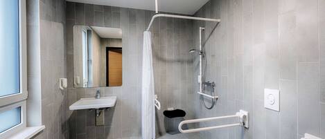 A modern bathroom with a shower, toilet, and sink.