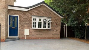 A single-story building with a blue door and a white-framed window. - 1bed Bungalow in the Heart of Moseley (Birmingham)