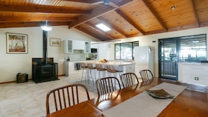 A spacious kitchen with a central island, wooden ceiling beams, and a dining area with a large table and chairs. - Lot 4 Retreat - 150 Willson Drive (NORMANVILLE)