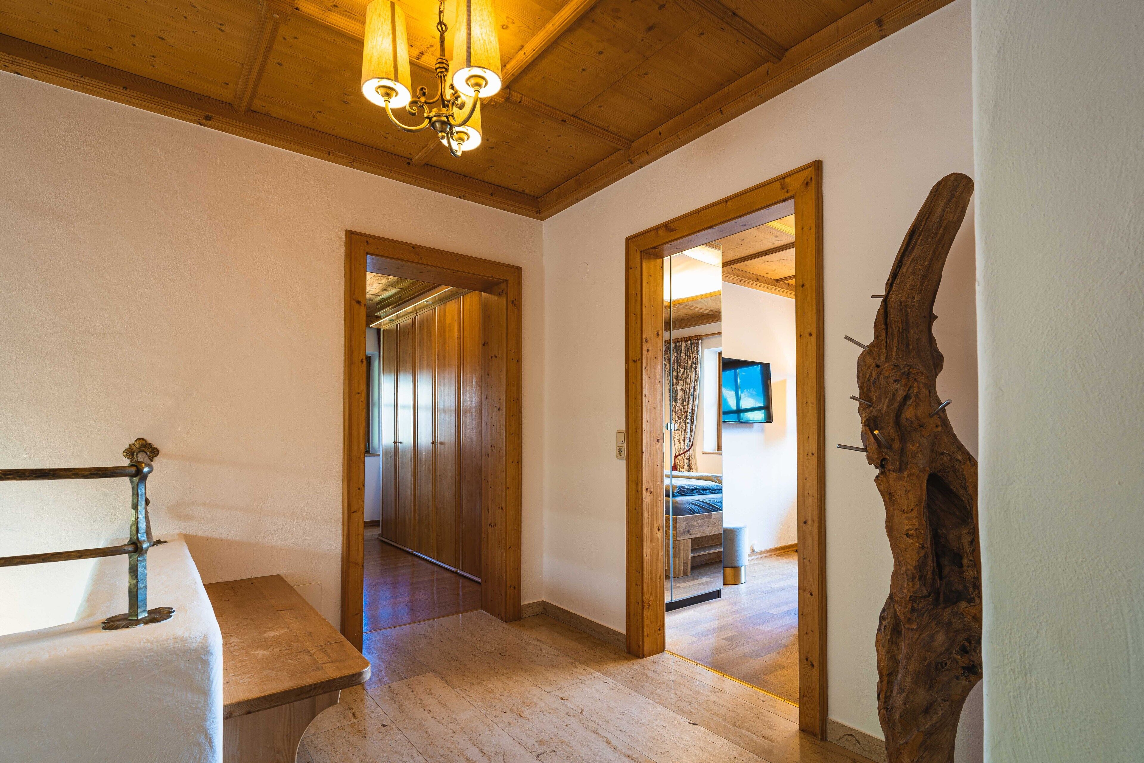 Un interno in legno con un grande specchio, un lampadario e una scultura in legno rustica.