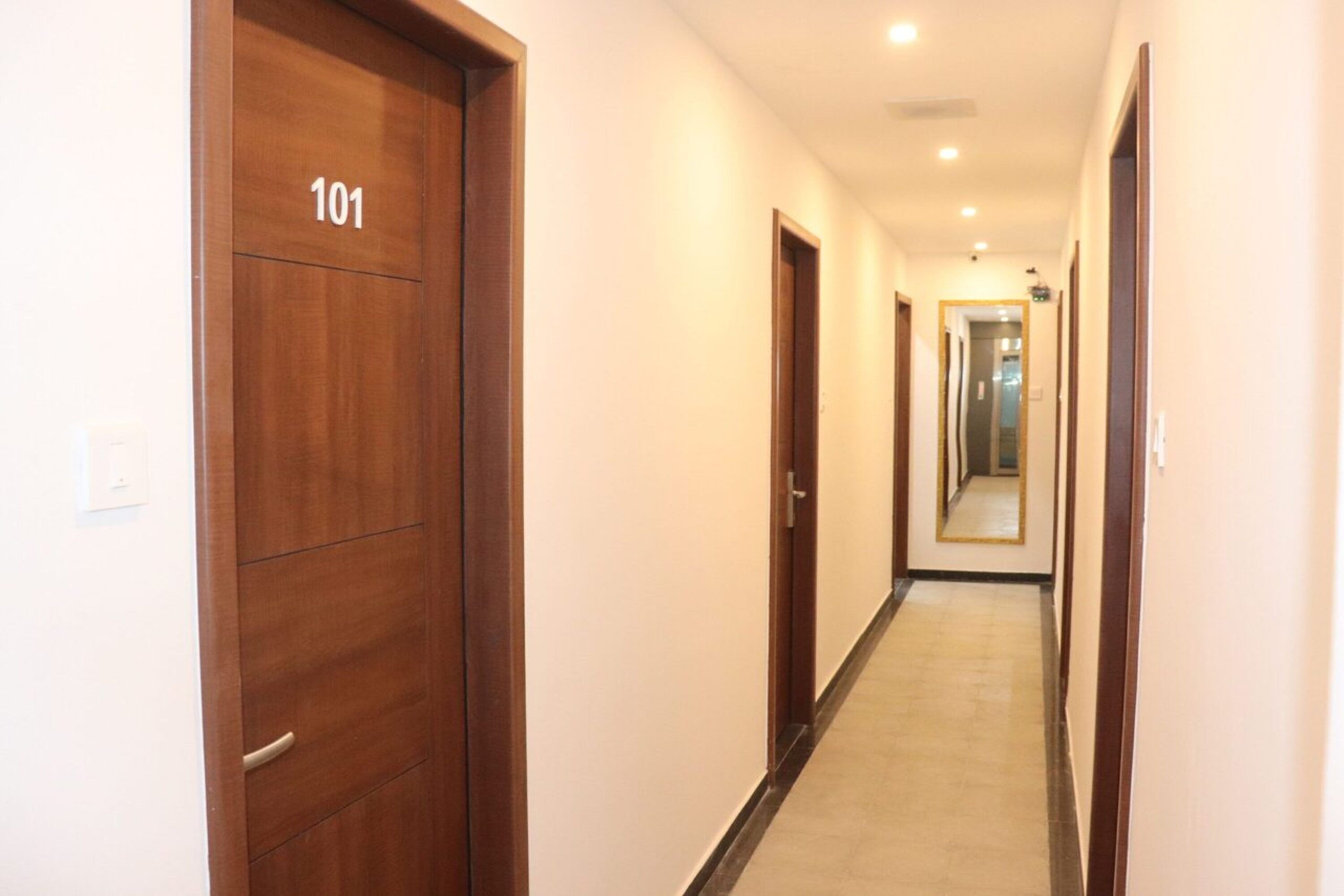 A corridor with wooden doors, one labeled '101'.