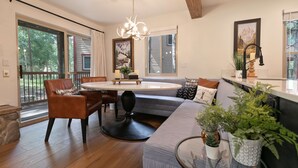 Ein modernes Wohnzimmer mit großem Fenster, Essbereich und Küche.