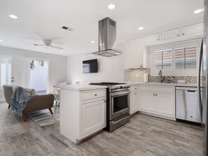 A modern kitchen with white cabinetry, a stainless steel range, and a built-in oven. - Mermaid Cove: Your private Pacific Beach Oasis! (San Diego)