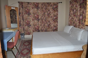 Relax in comfort with a large bed, desk, and chair.