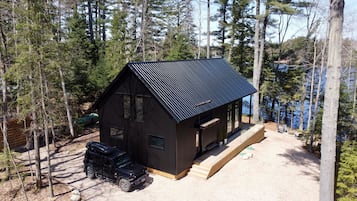 Escape to a secluded cabin surrounded by tall trees, with a spacious deck area and expansive views of the surrounding nature.