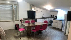 Une cuisine compacte avec un coin repas, un lave-linge et un téléviseur.