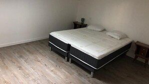 Une chambre à coucher avec un lit, une table de chevet et un luminaire au plafond.