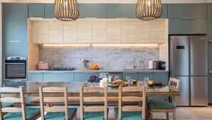 A modern kitchen with wooden cabinets, a central island, and a stainless steel refrigerator.