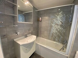 Bathtub, hair dryer, towels, shampoo