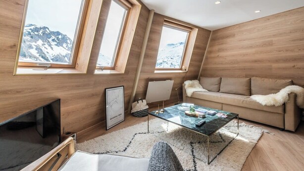 A modern living room with wooden walls, a glass coffee table, a sofa, and a TV. - Immodreams - Le Mountain Loft - Avoriaz (Avoriaz)