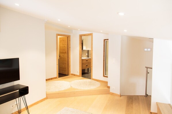 Ein modernes Interieur mit Holzboden, Flachbildfernseher und minimalistischem Design.