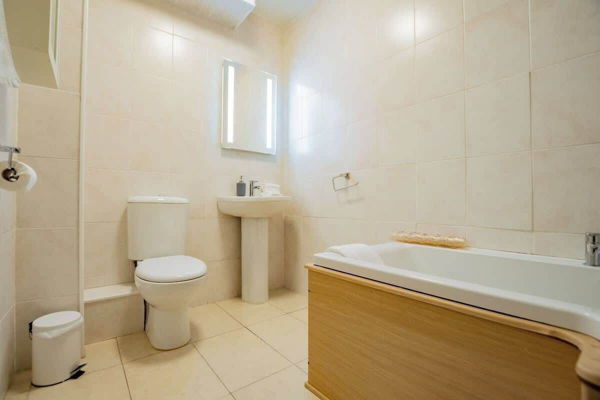 A modern bathroom with a toilet, sink, and bathtub.