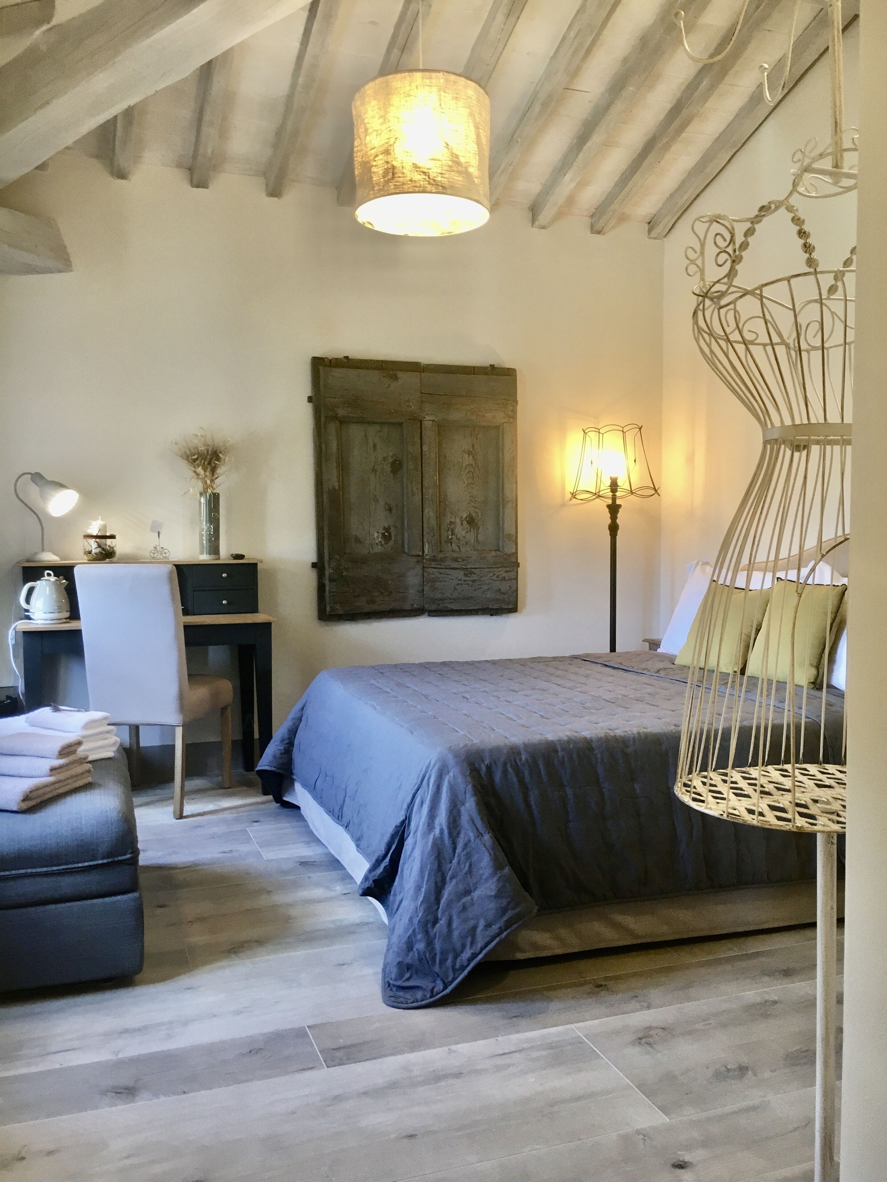 A bedroom with a bed, a desk, a chair, and a hanging chair.