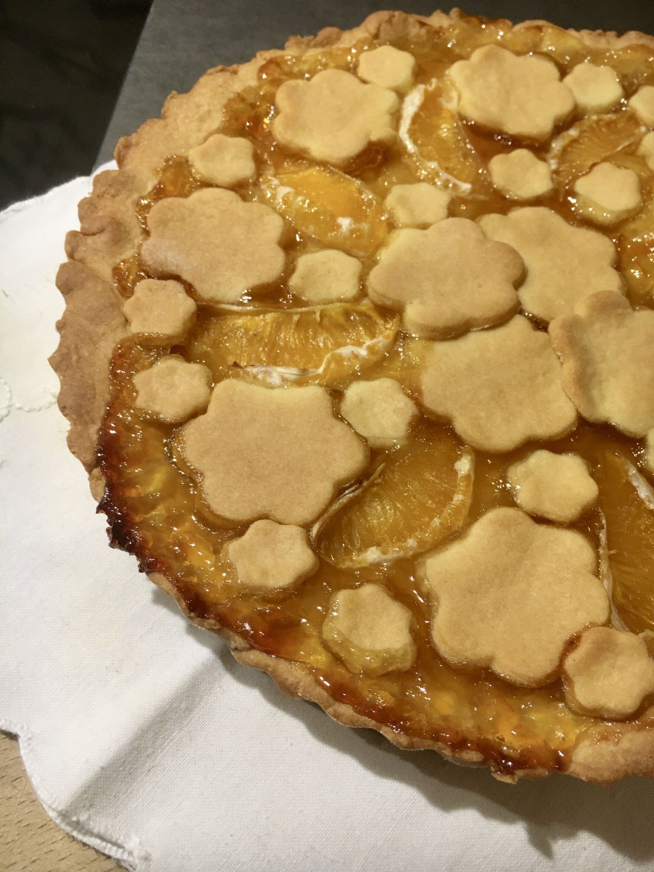 Ein Kuchen mit Gitterteig auf einer weißen Decke.