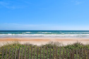A beach with a wooden fence in the foreground and the ocean in the background. - Coastal Classy | 5-min walk to quiet beach (Vilano Beach)