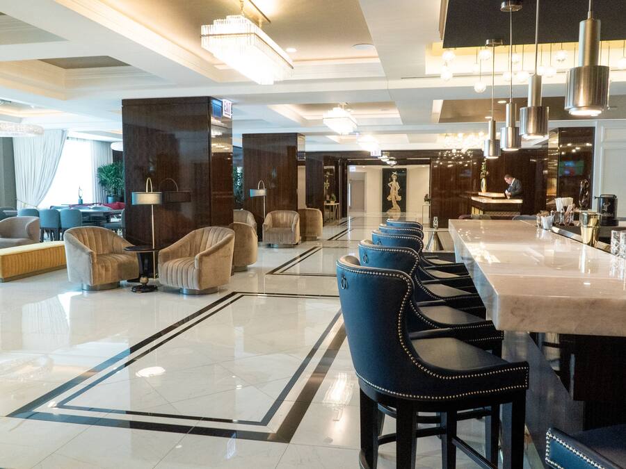 A modern hotel lobby with a bar area, seating arrangements, and a reception desk.