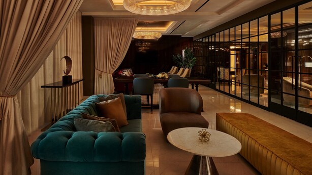 A spacious lobby with a plush teal sofa, a round coffee table, and a large chandelier. - The LaSalle Chicago, Autograph Collection by Marriott (Chicago)