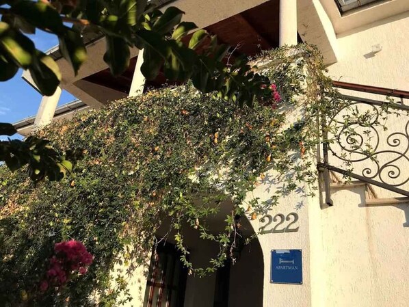 A building with a number '222' and a sign indicating 'APARTMAN'.