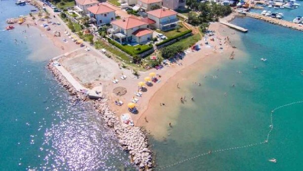 An aerial view of a coastal area with a beach, several buildings, and boats. - Holiday apartment with terrace overlooking the sea, air-conditioned, on the 1st floor (Klimno)