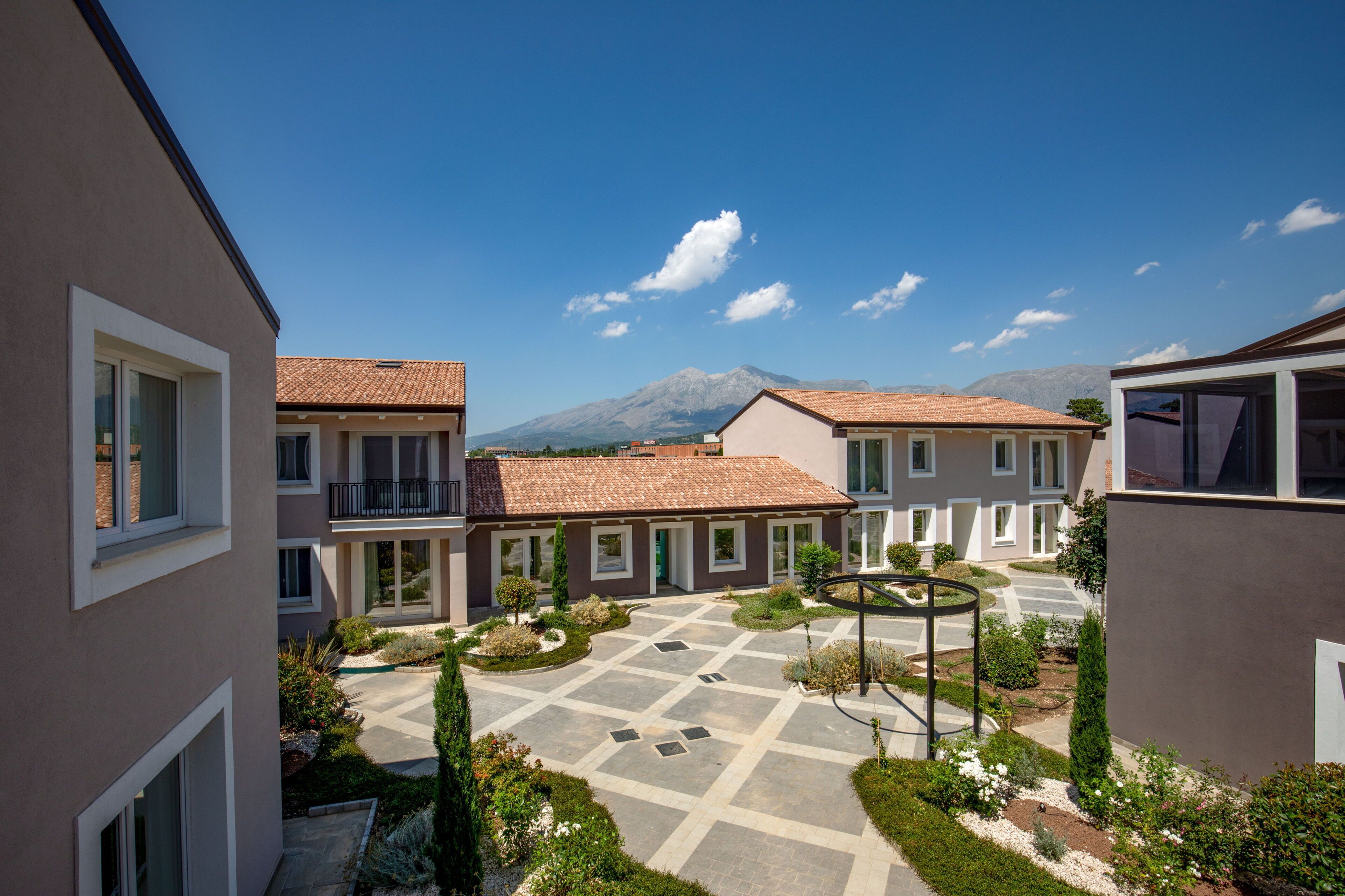 A courtyard with a tiled roof, surrounded by buildings with balconies and windows.