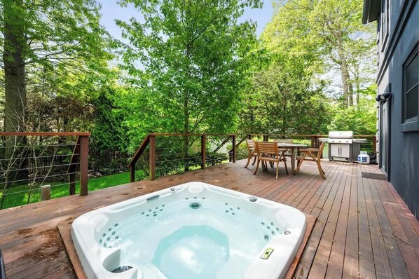 A wooden deck with a hot tub, outdoor furniture, and a grill area. - Year round Jacuzzi - Blackberry East Hampton Home (East Hampton)