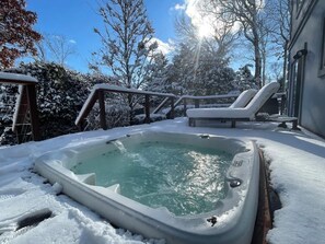 A hot tub surrounded by snow, with a wooden deck and lounge chairs. - Year round Jacuzzi - Blackberry East Hampton Home (East Hampton)