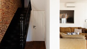 Un escalier avec un mur de briques d’un côté et une porte blanche en bas.