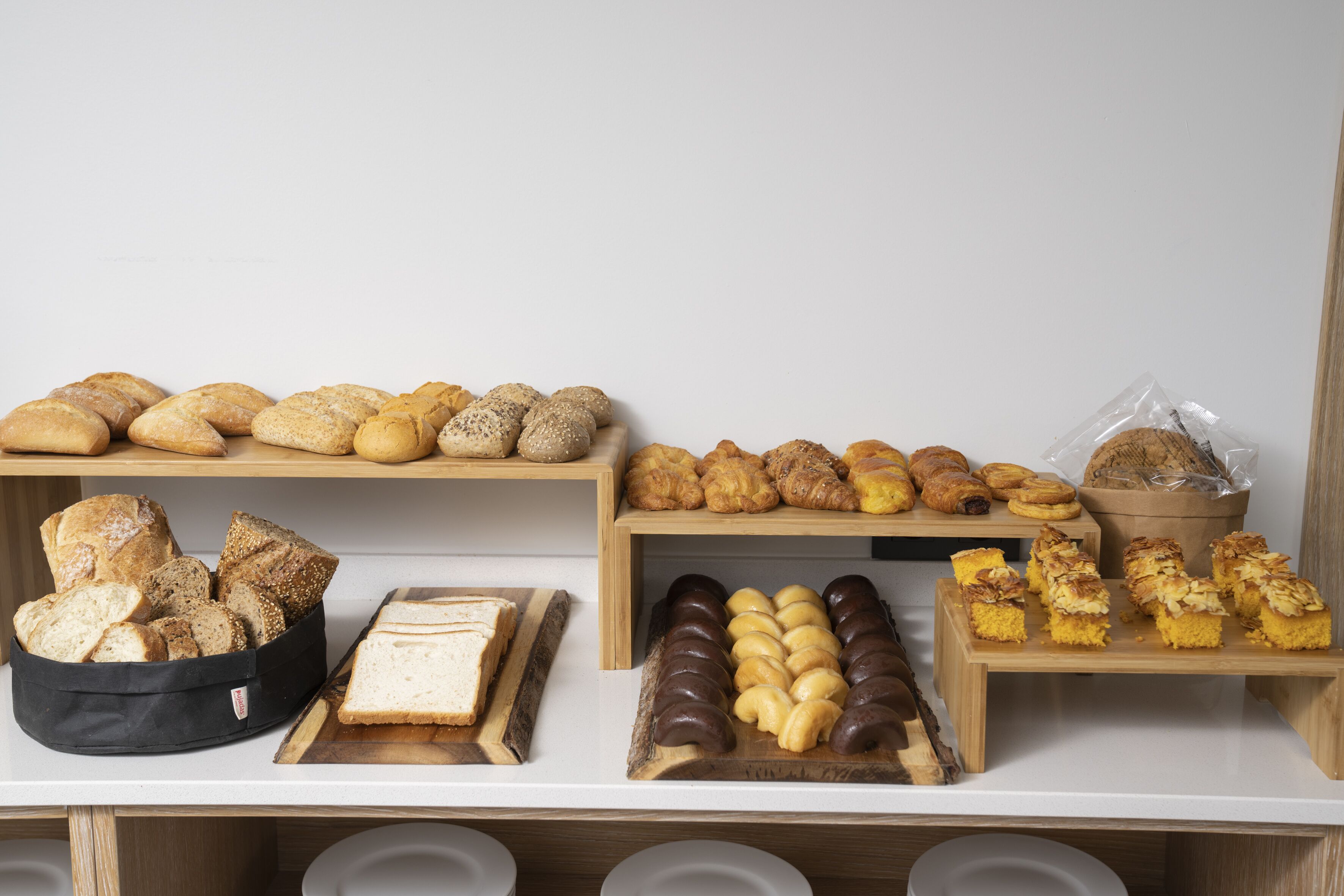 Una vitrina de panadería con panes, pasteles y tartas variados.