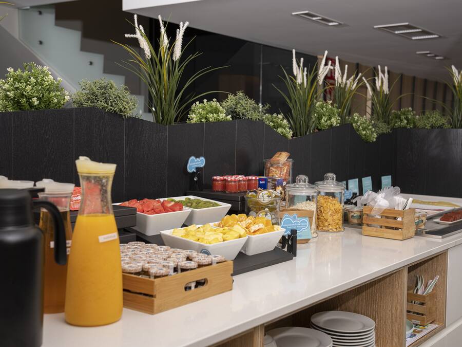 Un bufé con diversos alimentos y bebidas, como frutas, cereales y salsas.