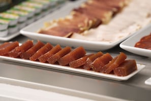 A buffet with various food items, including a dish with cubed meat and a plate with a glazed dessert. - Hotel Meiga do Mar & Spa (Carnota)